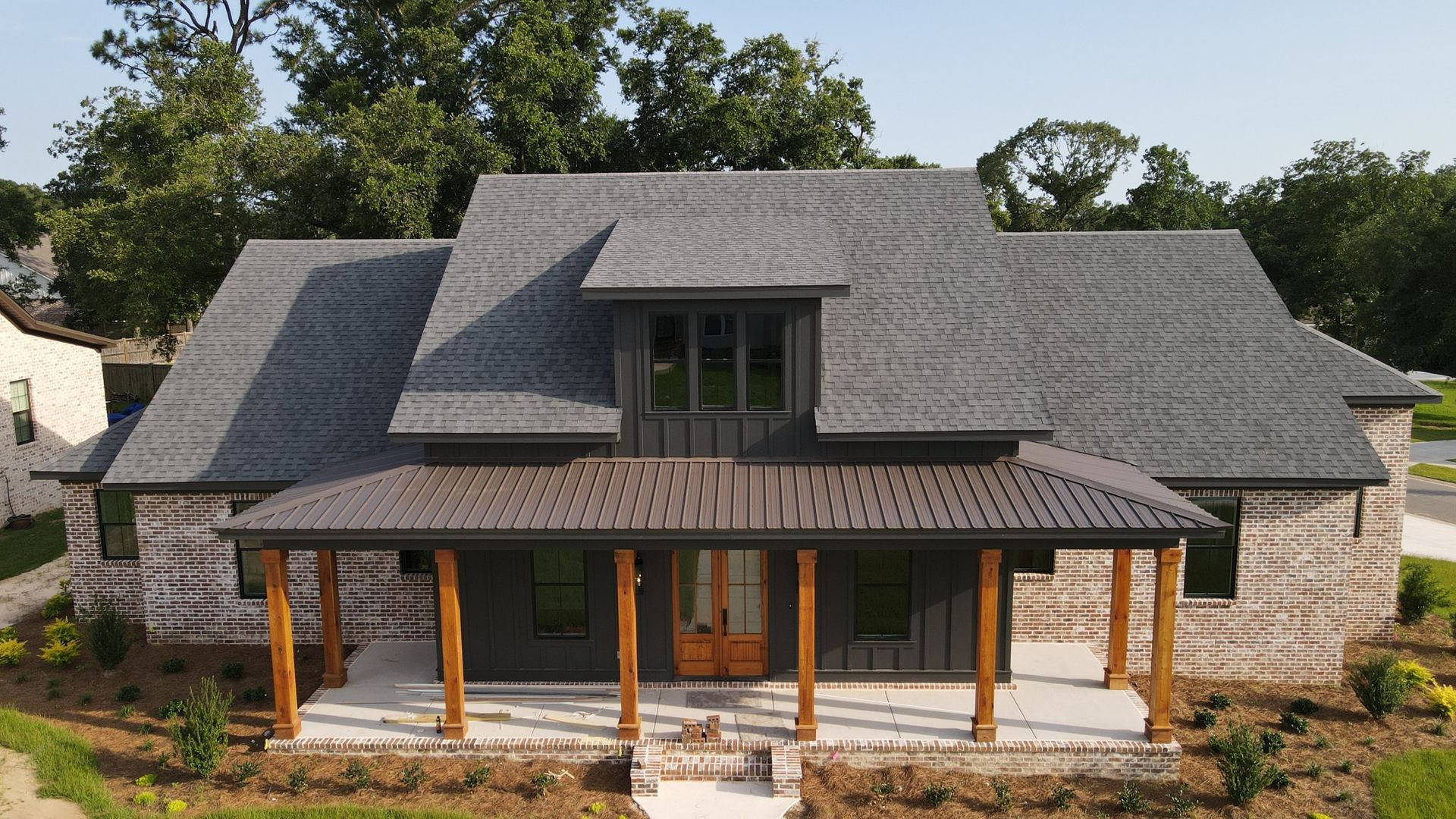 Brick home with a full shingle roof replacement and metal porch roof